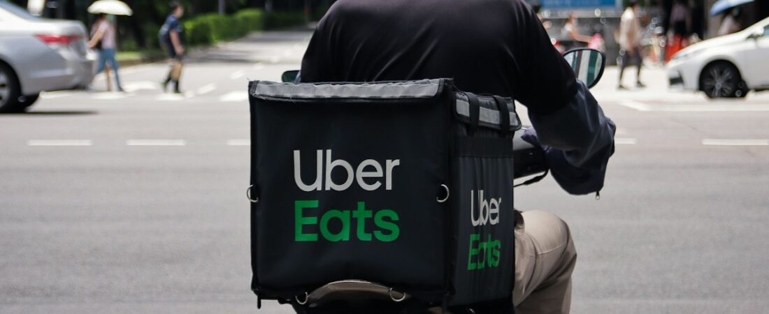 DoorDash delivery driver with red bag in a US residential area.